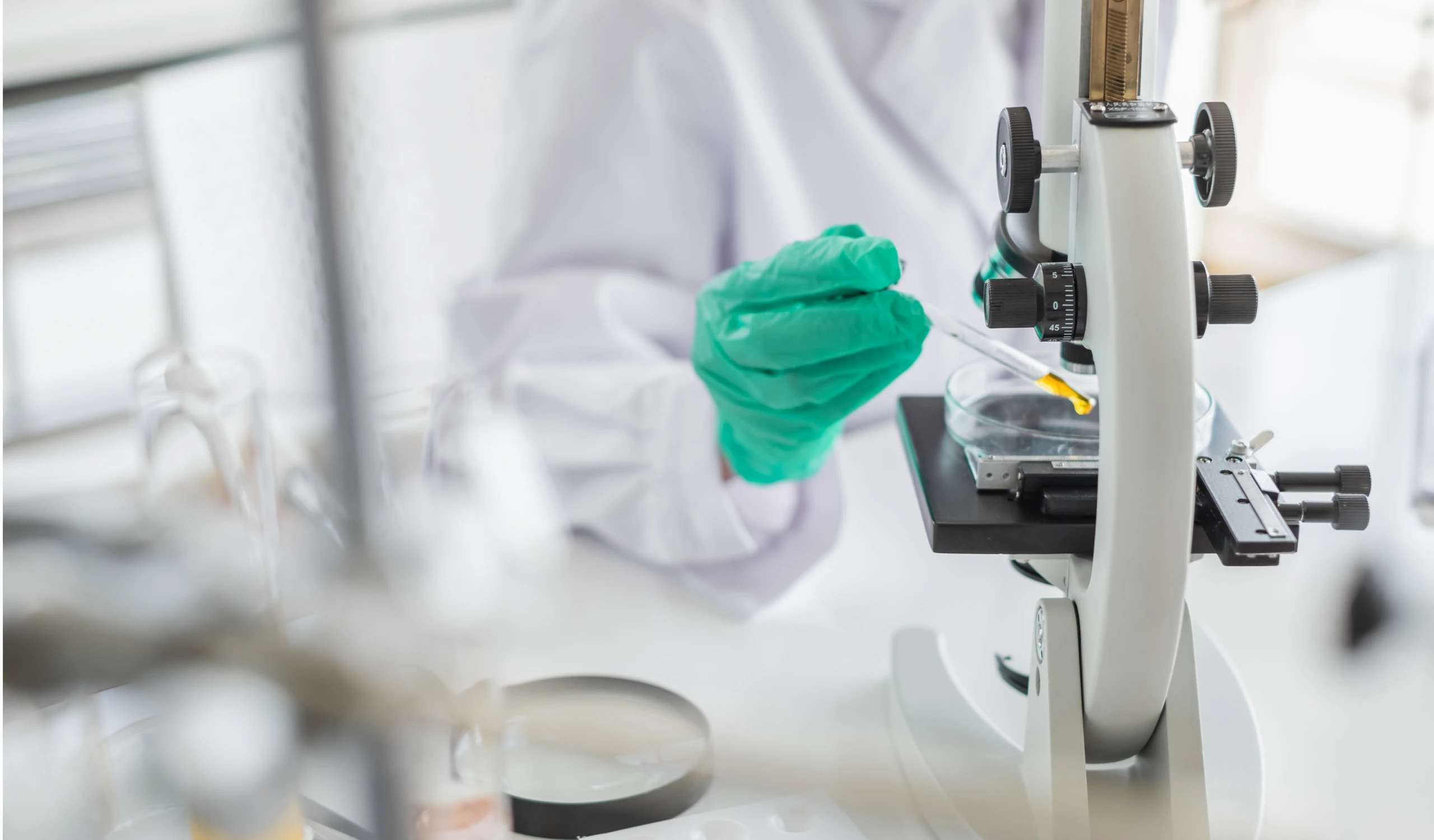 Lab technician inspecting liquid formulation in product quality lab